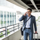 Businessmvoyageurs d'affairesan on business trip telephoning with smartphone