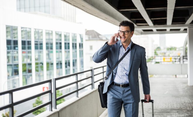 Businessmvoyageurs d'affairesan on business trip telephoning with smartphone